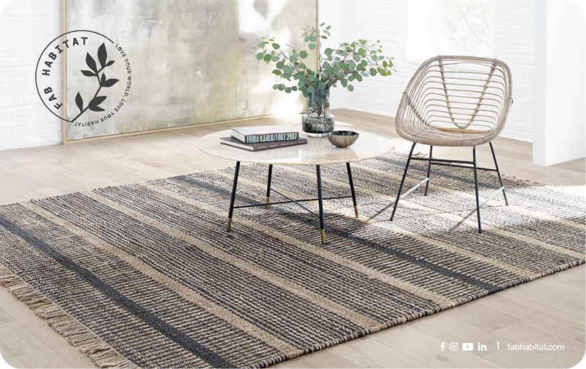 Full view of gift card showing living room with striped rug, glass table and rattan chair